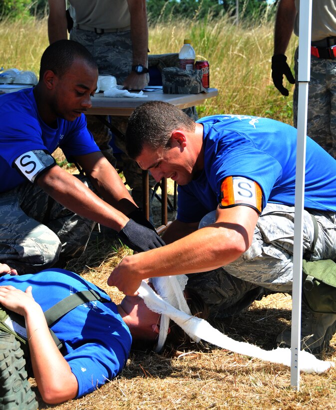 Airmen treat an acting wounded troop, July 28, 2011 at Joint Base Lewis-McChord, Wash., during an aerial port obstacle course. The event was part of Air Mobility Rodeo 2011, a biennial international competition that focuses on mission readiness, featuring airdrops, aerial refueling and other events that showcase the skills of mobility crews from around the world. (U.S. Air Force photo/Airman 1st Class Jared Trimarchi) 