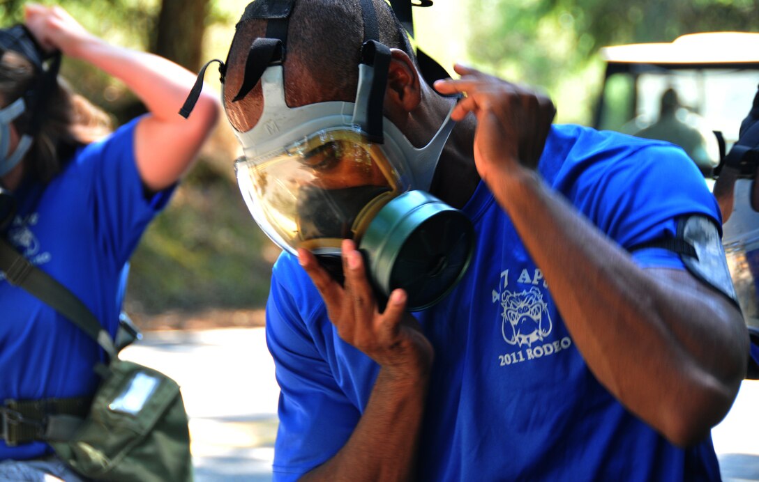 An Airman dons his gas mask, July 28, 2011 at Joint Base Lewis-McChord, Wash., during an aerial port obstacle course. The event was part of Air Mobility Rodeo 2011, a biennial international competition that focuses on mission readiness, featuring airdrops, aerial refueling and other events that showcase the skills of mobility crews from around the world. (U.S. Air Force photo/Airman 1st Class Jared Trimarchi) 