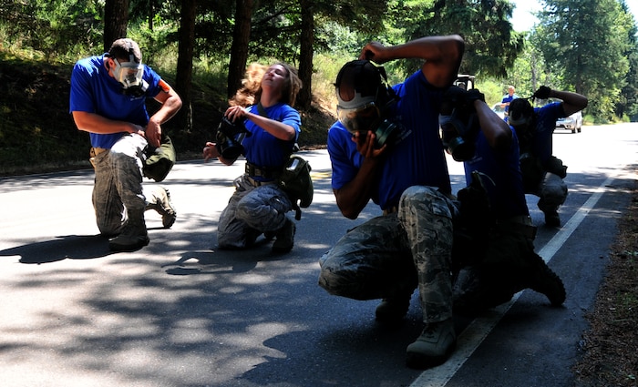 Airmen don their gas masks, July 28, 2011 at Joint Base Lewis-McChord, Wash., during an aerial port obstacle course. The event was part of Air Mobility Rodeo 2011, a biennial international competition that focuses on mission readiness, featuring airdrops, aerial refueling and other events that showcase the skills of mobility crews from around the world. (U.S. Air Force photo/Airman 1st Class Jared Trimarchi) 
