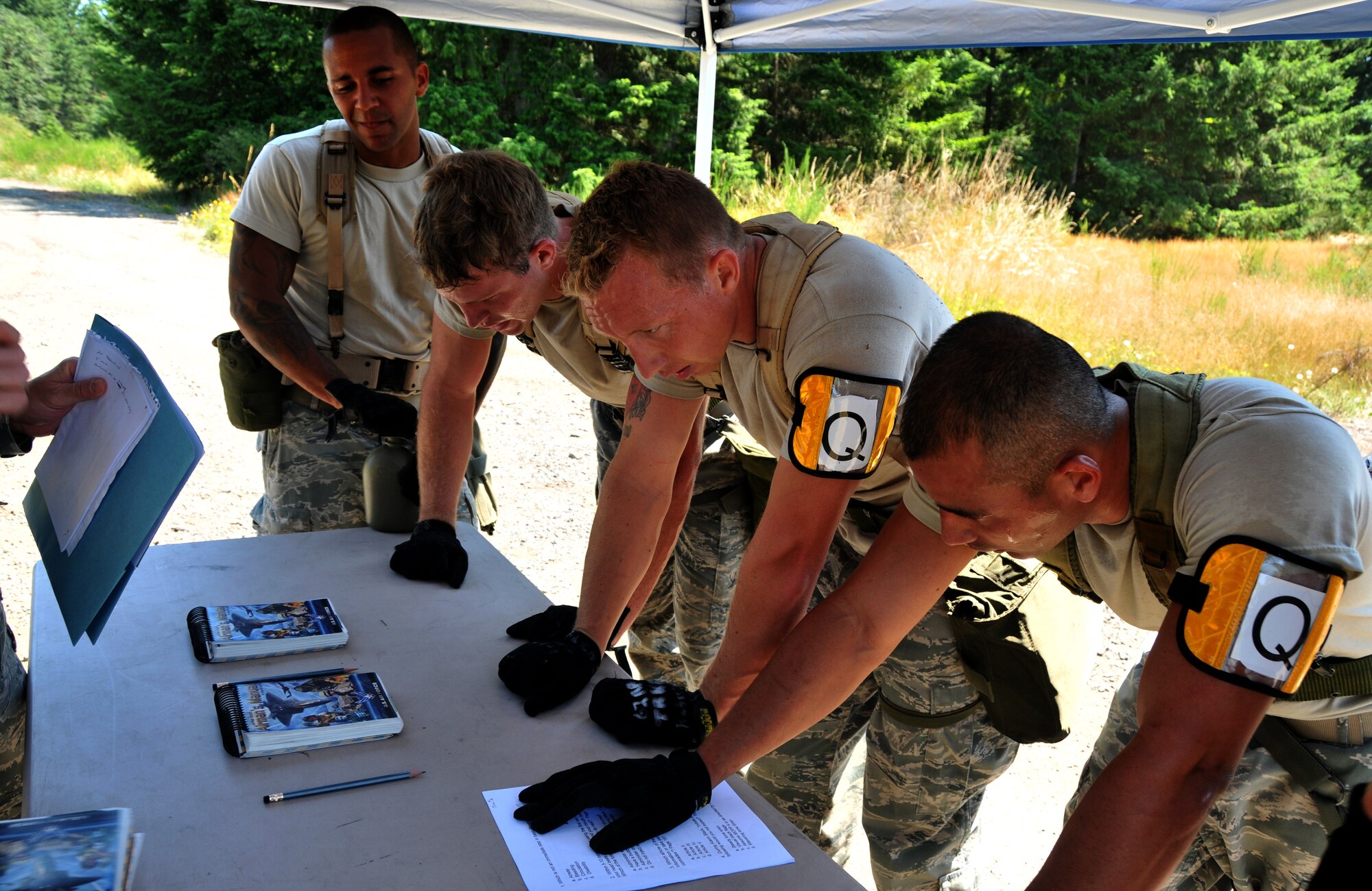 Airmen catch their breaths before taking a five-question test, July 28, 2011 at Joint Base Lewis-McChord, Wash., during an aerial port obstacle course. The event was part of Air Mobility Rodeo 2011, a biennial international competition that focuses on mission readiness, featuring airdrops, aerial refueling and other events that showcase the skills of mobility crews from around the world. (U.S. Air Force photo/Airman 1st Class Jared Trimarchi) 
