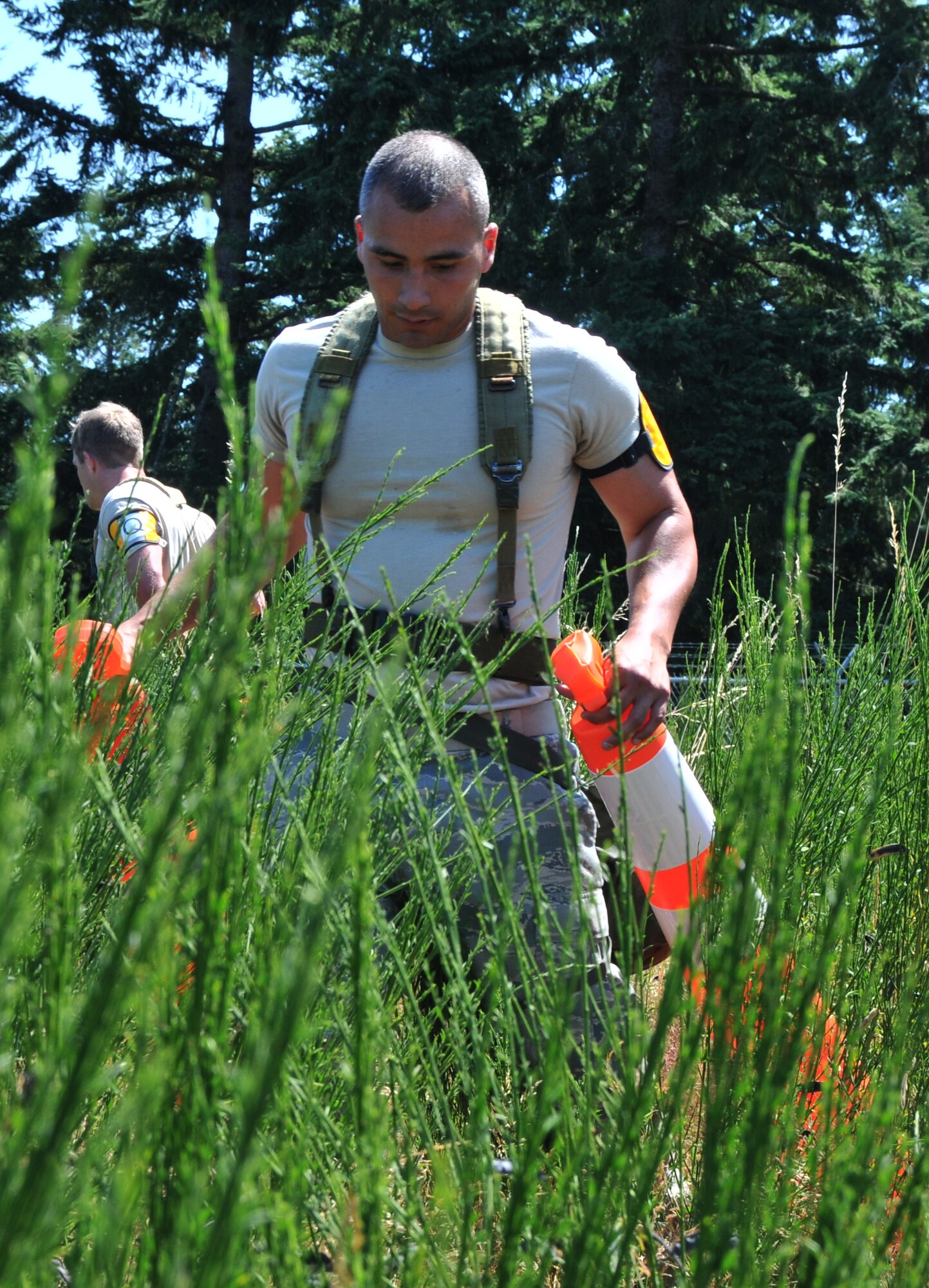 An Airman searches for an unexploded ordnance, July 28, 2011 at Joint Base Lewis-McChord, Wash., during an aerial port obstacle course. The event was part of Air Mobility Rodeo 2011, a biennial international competition that focuses on mission readiness, featuring airdrops, aerial refueling and other events that showcase the skills of mobility crews from around the world. (U.S. Air Force photo/Airman 1st Class Jared Trimarchi) 

