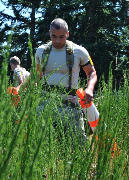 An Airman searches for an unexploded ordnance, July 28, 2011 at Joint Base Lewis-McChord, Wash., during an aerial port obstacle course. The event was part of Air Mobility Rodeo 2011, a biennial international competition that focuses on mission readiness, featuring airdrops, aerial refueling and other events that showcase the skills of mobility crews from around the world. (U.S. Air Force photo/Airman 1st Class Jared Trimarchi) 