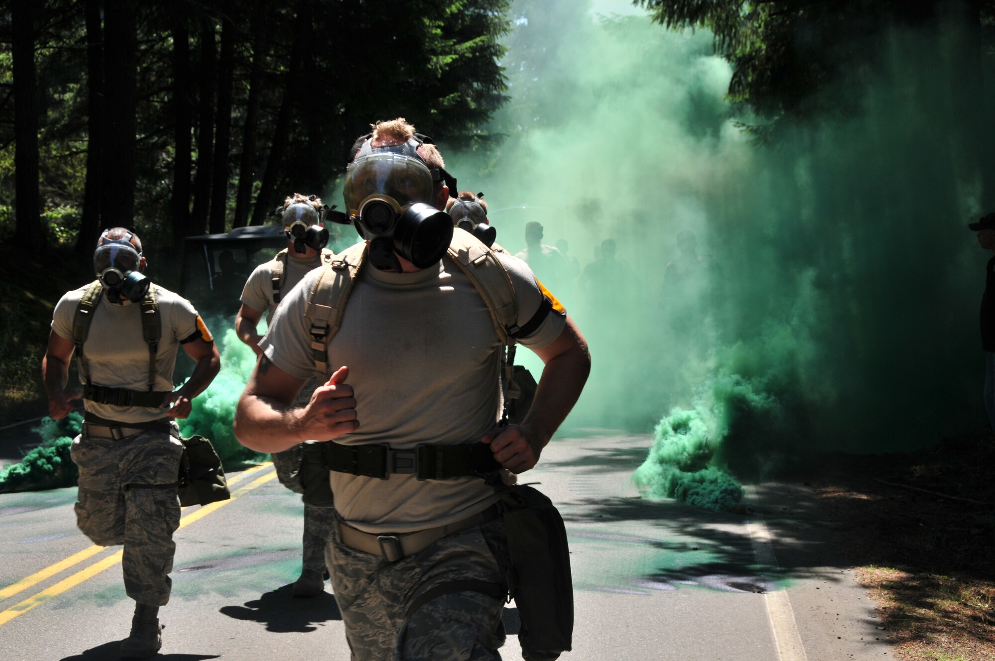 Airmen jog with donned gas masks, July 28, 2011 at Joint Base Lewis-McChord, Wash., during an aerial port obstacle course. The event was part of Air Mobility Rodeo 2011, a biennial international competition that focuses on mission readiness, featuring airdrops, aerial refueling and other events that showcase the skills of mobility crews from around the world. (U.S. Air Force photo/Airman 1st Class Jared Trimarchi) 
