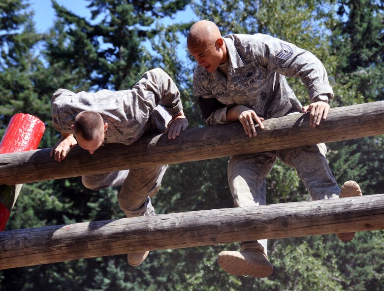 Staff Sgt, Jade Mcleod and Staff Sgt. Cedric Hollman, 60th Air Mobility Wing, participate in the wall climb challenge during the Security Forces combat endurance course at the Air Mobility Rodeo 2011 July 28, 2011 at Joint Base Lewis-McChord, Wash. (U.S. Air Force photo/Airman 1st Class Michael Battles)