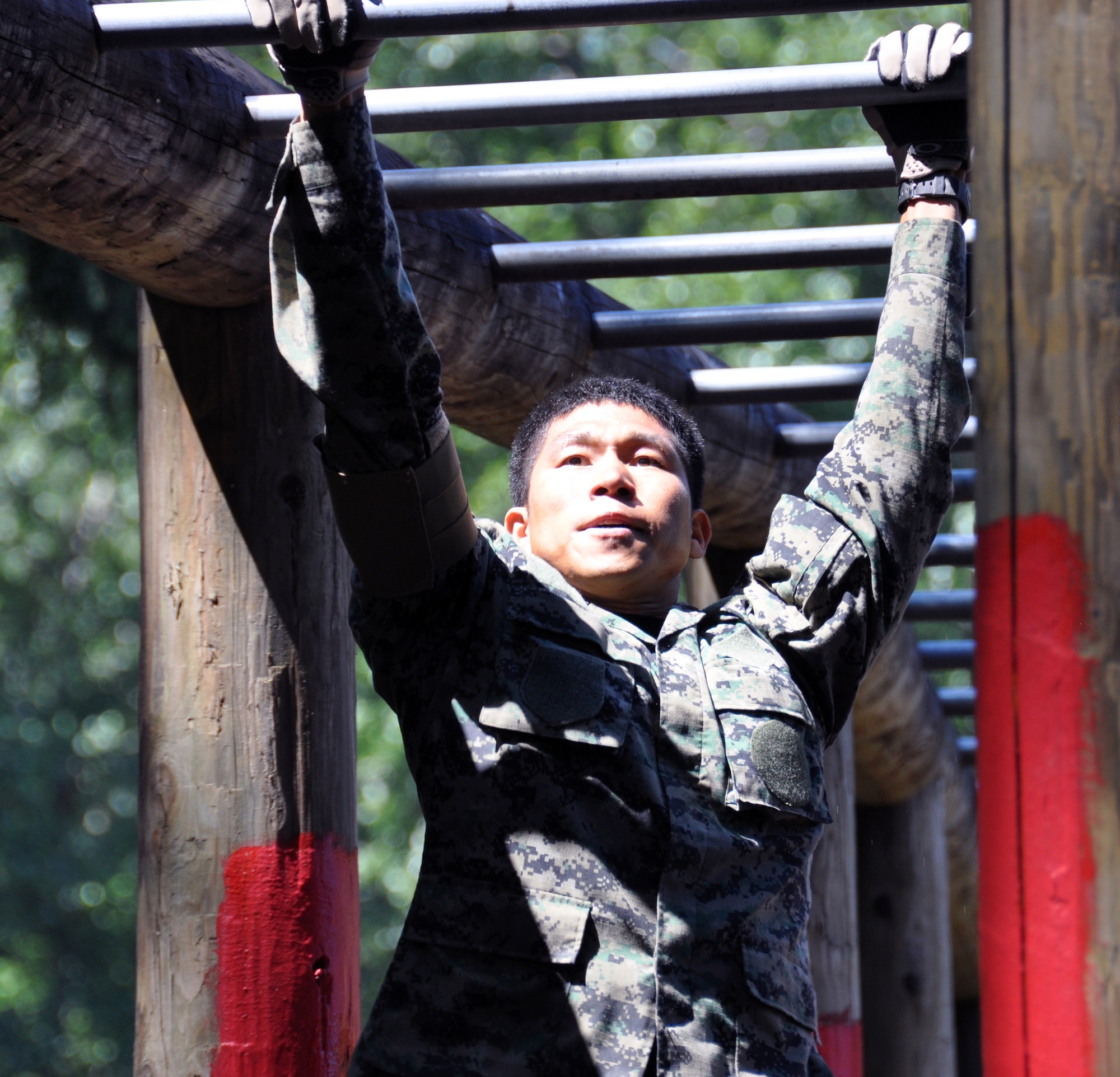 A member of the Republic of Korea air force, participates in the monkey bar challenge during the Security Forces combat endurance course at the Air Mobility Rodeo 2011 July 28, 2011 at Joint Base Lewis-McChord, Wash. (U.S. Air Force photo/Airman 1st Class Michael Battles)