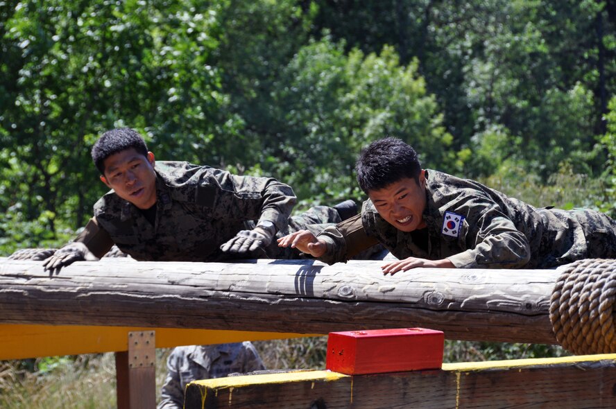 Members of the Republic of Korea air force, participate in the log roll events during the Security Forces combat endurance course at the Air Mobility Rodeo 2011 July 28, 2011 at Joint Base Lewis-McChord, Wash. (U.S. Air Force photo/Airman 1st Class Michael Battles)