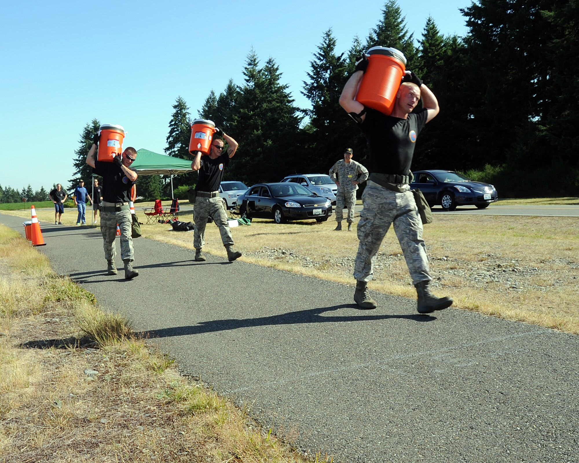 JOINT BASE LEWIS-MCCHORD, Wash. – Staff Sgt. Michael Ladrigan, Airman 1st Class Joshua Verran and Senior Airman William Martineau, 97th Logistics Readiness Squadron Rodeo Team members from Altus Air Force Base, Okla., carry water coolers filled with water as part of the 2011 Air Mobility Command Rodeo Challenge Course July 28, 2011. During the Challenge Course, the five-man team from 97th LRS ran a 3.6 mile, 14-obstacle course intended to challenge their physical ability and team work. (U.S. Air Force photo by Airman 1st Class Kenneth W. Norman / Released / 97th Air Mobility Wing Rode Public Affairs)