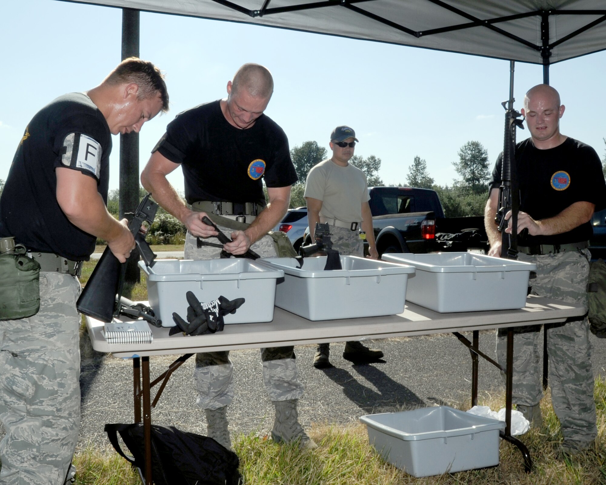 JOINT BASE LEWIS-MCCHORD, Wash. – (L to R) Senior Airmen Eric Hazlewood, William Martineau and Staff Sgt. Eric Sims, 97th Logistics Readiness Squadron Rodeo Team members from Altus Air Force Base, Okla., assemble M-16 rifles during the 2011 Air Mobility Command Rodeo Challenge Course July 28, 2011. During the Challenge Course, the five-man team from 97th LRS ran a 3.6 mile, 14-obstacle course that challenged their physical ability and team work. (U.S. Air Force photo by Airman 1st Class Kenneth W. Norman / Released / 97th Air Mobility Wing Rode Public Affairs)