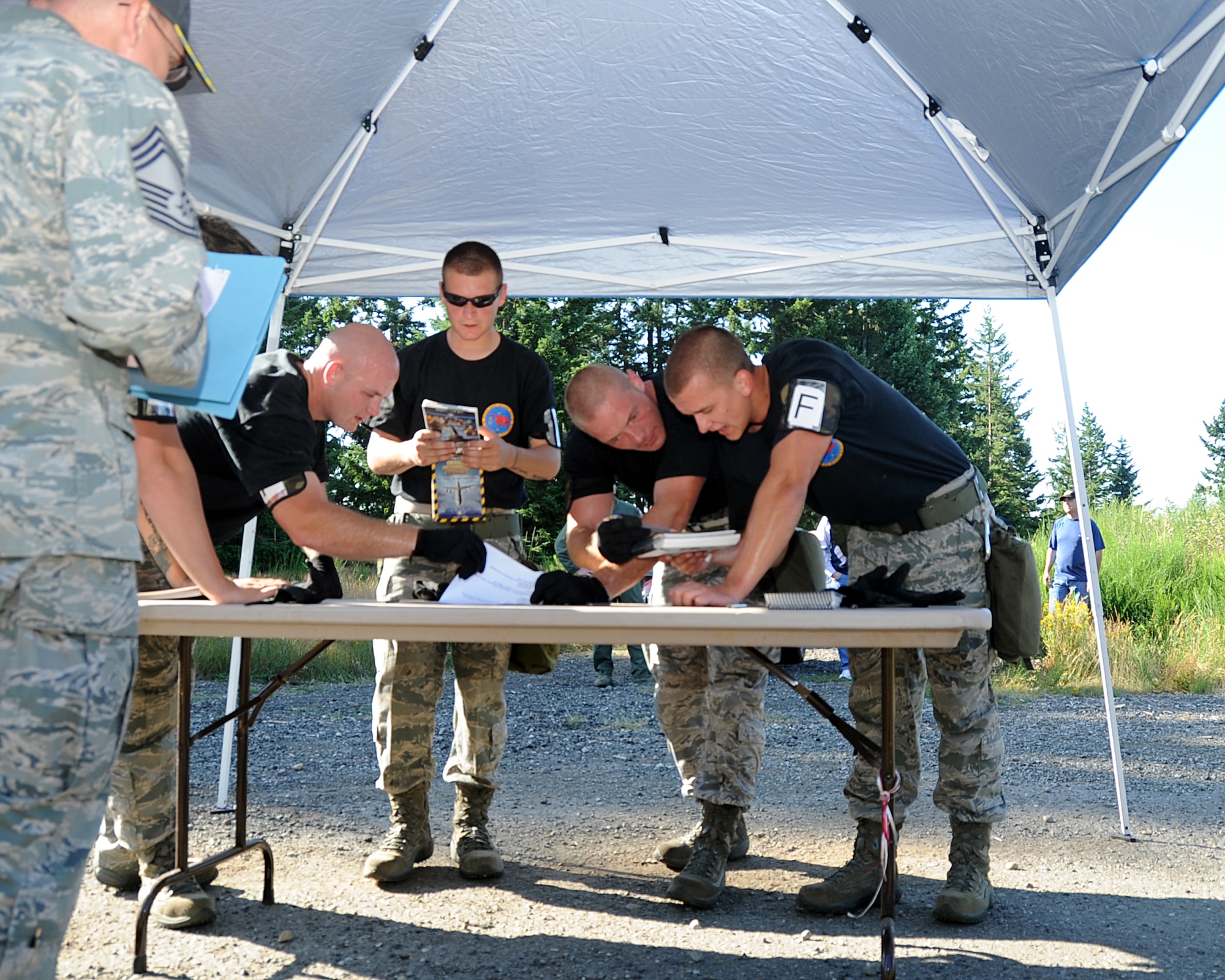 JOINT BASE LEWIS-MCCHORD, Wash. – The 97th Logistics Readiness Squadron Rodeo Team from Altus Air Force Base, Okla., answers 20 questions from the Airman’s Manual at a mental challenge station during the 2011 Air Mobility Command Rodeo Challenge Course July 28, 2011. During the Challenge Course, the five-man team from 97th LRS ran a 3.6 mile, 14-obstacle course that challenged their physical ability and team work. (U.S. Air Force photo by Airman 1st Class Kenneth W. Norman / Released / 97th Air Mobility Wing Rode Public Affairs)