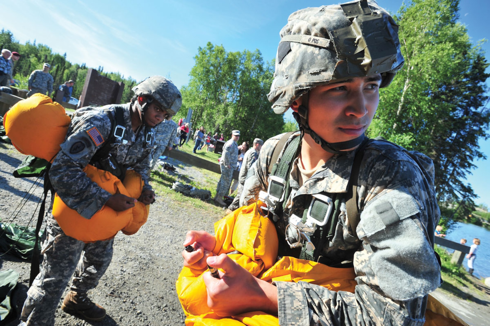 Spc. Paul Tabor and Spc. Sydney Stevens, both 1st Battalion (Airborne) 501st Infantry Regiment, deflate life preservers after parachute training and a water landing exercise at Big Lake, July 22. Several hundred Soldiers jumped from UH-60 helicopters into Big Lake. (U.S. Air Force photo/Justin Connaher)