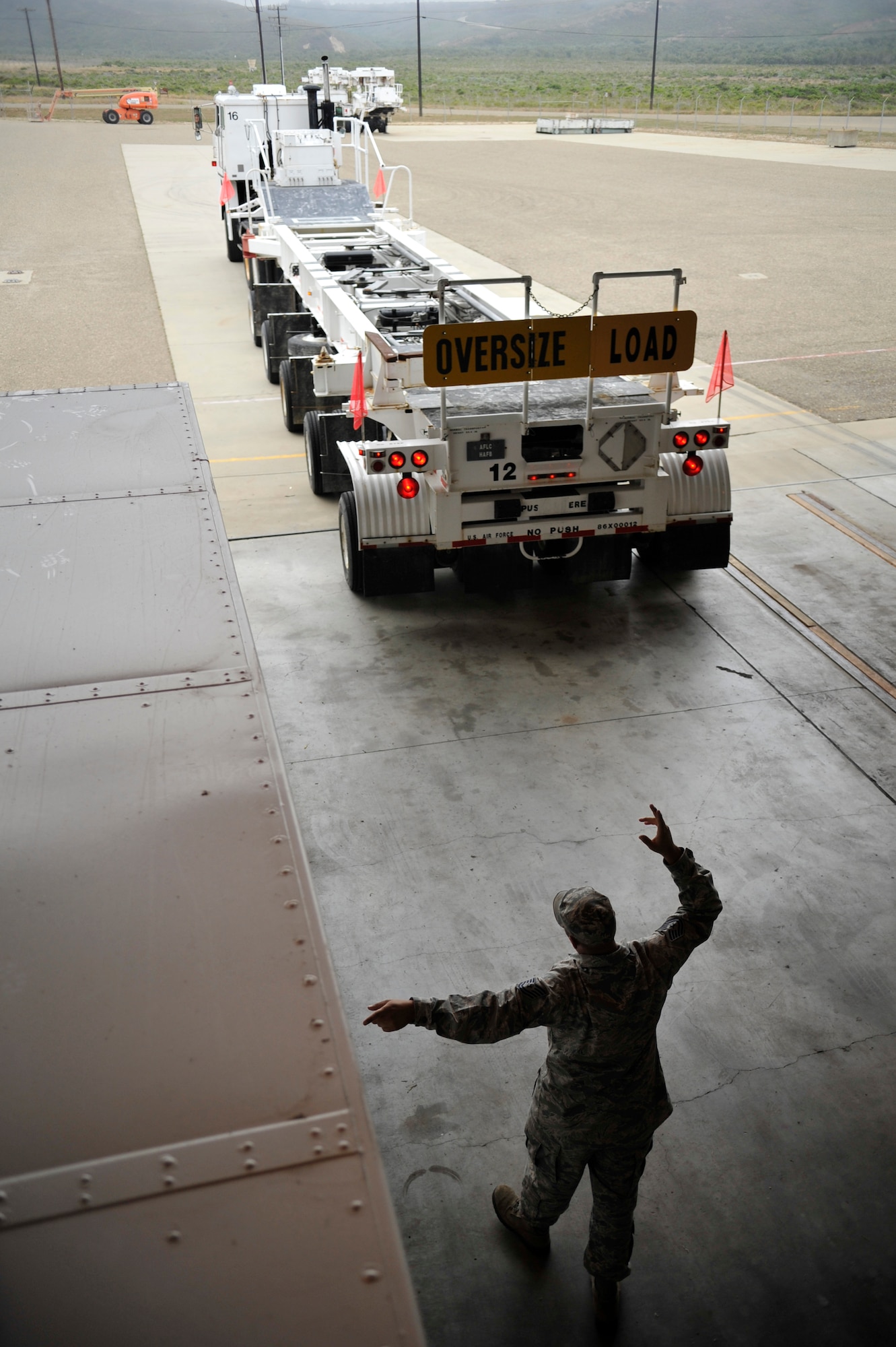 VANDENBERG AIR FORCE BASE, Calif. -- Tech. Sgt. Christopher Lanchoney, a 1st Air and Space Test Squadron maintenance trainer, ground guides a transport vehicle into a bay during a training session here Tuesday, July 19, 2011.  (U.S. Air Force photo/Staff Sgt. Andrew Satran) 

 
  