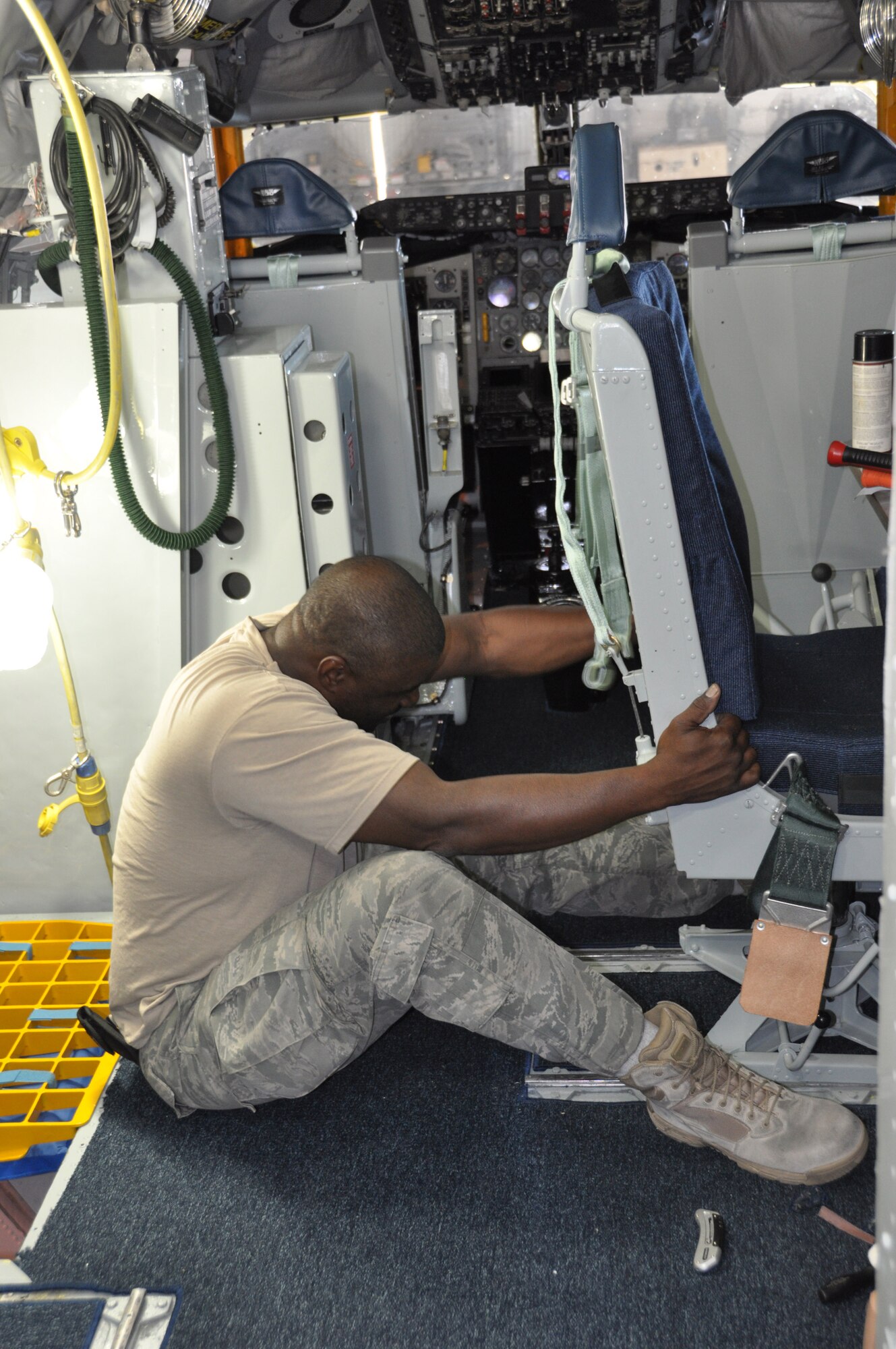 Tech. Sgt. Ronn Hutchinson leverages the navigator's into place in the flight cabin of a newly refurbished KC-135 Stratotanker at March Air Reserve Base, Calif., July 19, 2011. Hutchinson is a crew chief with the 752nd Aircraft Maintenance Squadron. (U.S. Air Force photo/Megan Just)