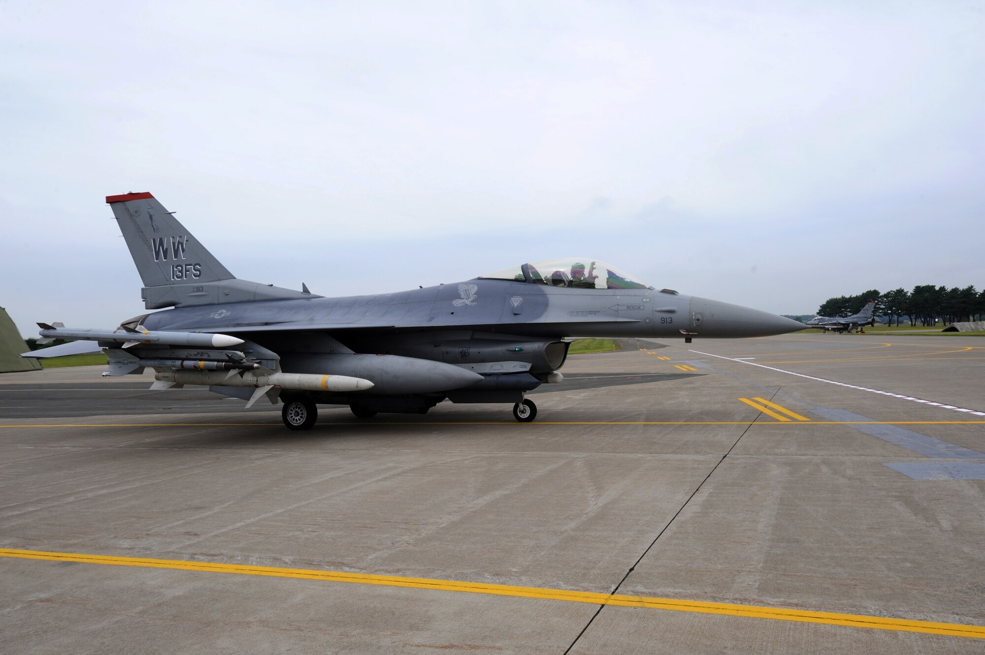 MISAWA AIR BASE, Japan -- Lt. Col. Gregory Kreuder, 13th Fighter Squadron, signals the claws of the Panther "the 13th FS's hand sign" as he moves down the taxi-way during a training exercise July 28.  The 35th Fighter Wing is engaged in a three-day pre-deployment exercise, simulating a variety of scenarios in a pre-combat environment.  (U.S. Air Force photo/Staff Sgt. April Quintanilla)