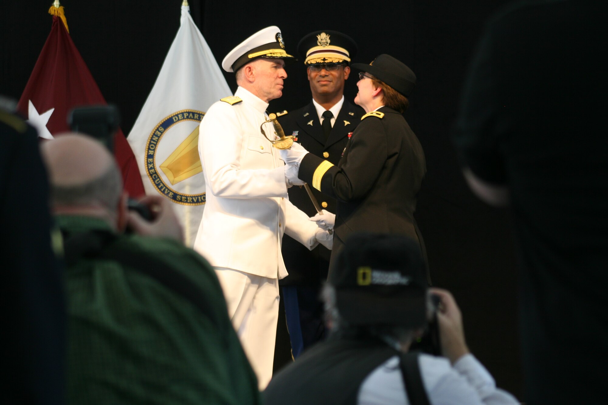 Army Maj. Gen. Carla Hawley-Bowland (right), commander of Walter Reed Army Medical Center in Washington, D.C., passes the Walter Reed sword to the National Naval Medical Center's commanding officer, Navy Rear Adm. Matthew L. Nathan, during a July 27, 2011, ceremony marking the casing of Walter Reed’s colors The two hospitals are consolidating in Bethesda, Md., to form the Walter Reed National Military Medical Center. (Defense Department photo/Terri Moon Cronk)