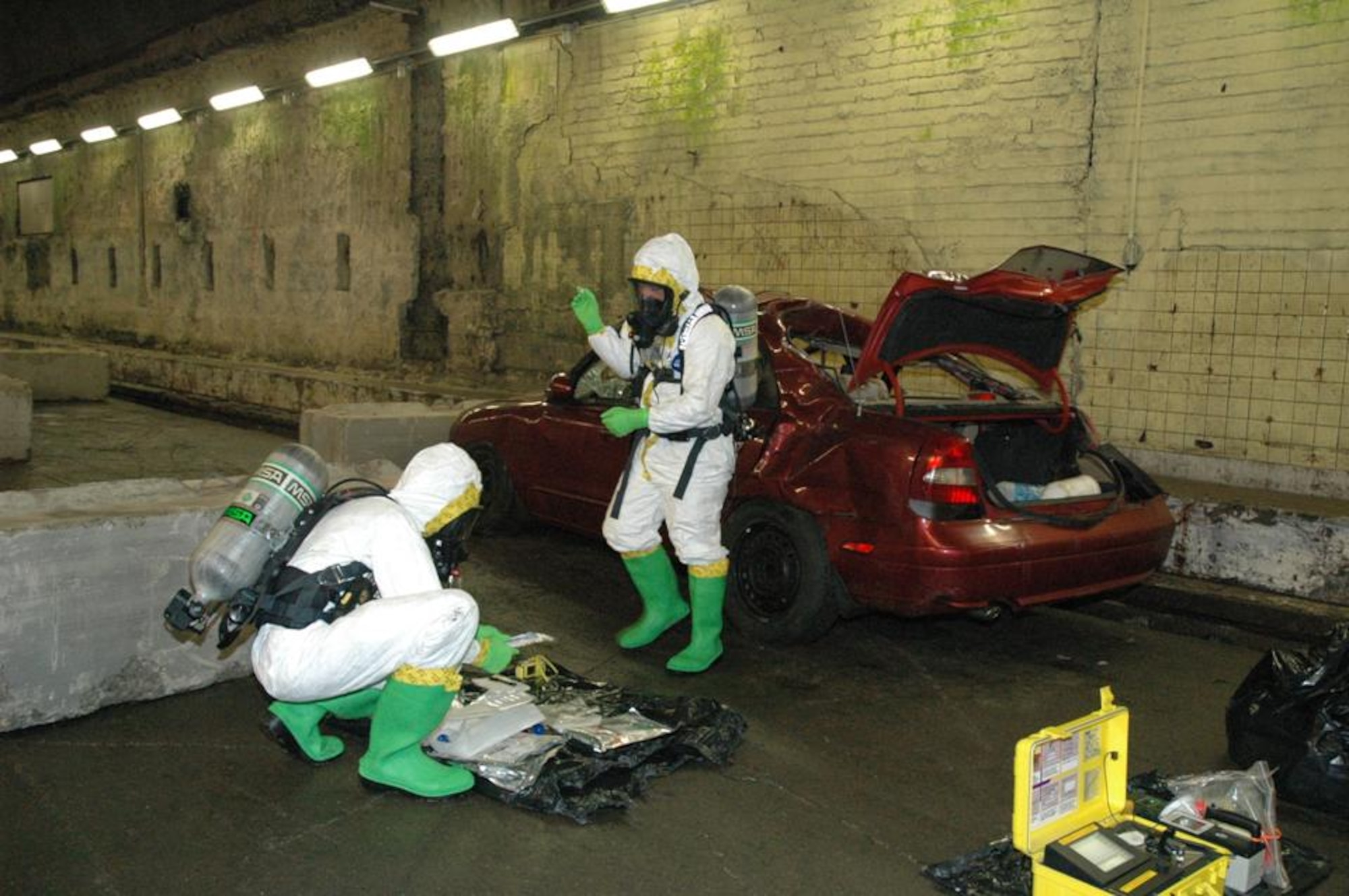 Emergency managers wearing Level A suits respond to a possible chemical, biological, radiological, and nuclear threat as a part of CBRN Challenge 2011. Level A suits allow emergency management personnel to enter and work in contaminated or toxic environments. (U.S. Air Force photo/Lisa Cymmer)