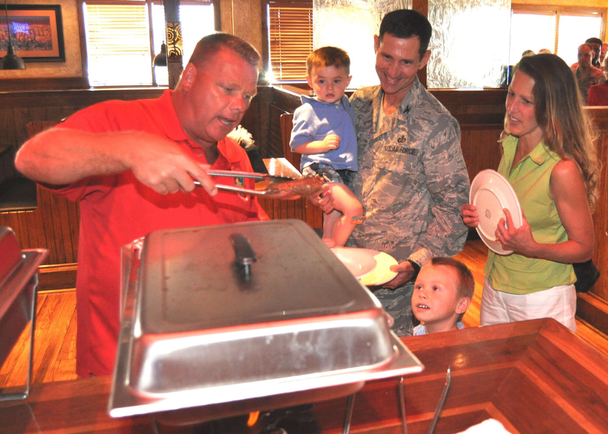 From left, Chief Master Sgt. Michael Skidmore, 81st Aerospace Medicine Squadron superintendent, serves steaks to Col. Rodney Berk, 81st Mission Support Group commander; his wife Laurie and their two sons, 20-month-old Ricky and 5-year-old Brennan, at the chiefs’ group steak sale at the Outback Steakhouse in D’Iberville, July 14. The event raised $1,750 for support of Keesler’s enlisted force. (U.S. Air Force photo by Steve Pivnick)