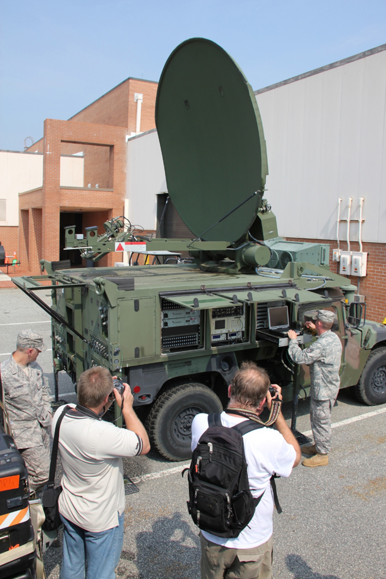 From left, Master Sgt. Charles Starnes, 53rd Combat Communications Squadron RF transmissions NCOIC, and Staff Sgt. Brian Dexter, 51st Combat Communications Squadron RF transmissions maintainer, demonstrate the PHOENIX tactical satellite terminal-configured Humvee to the artists.U.S. Air Force photo by Robert Talenti