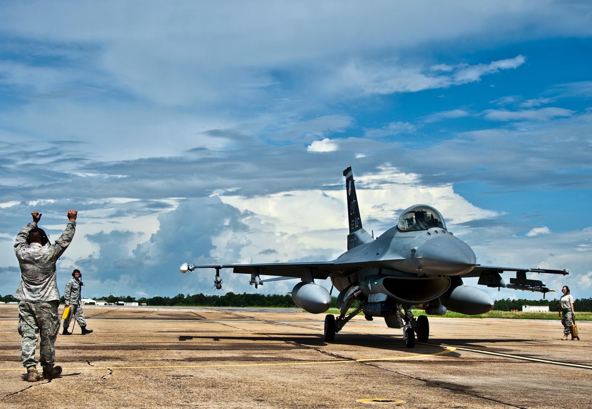 Airman 1st Class Josh Mouser, a 46th Maintenance Group crew chief, gives the stop command to an arriving F-16 Fighting Falcon pilot at Eglin Air Force Base, Fla., July 22.  The 46th Maintenance Group maintains A-10s, F-16s, F-15s, and other aircraft for both the 46th TW and 53rd Wing.  (U.S. Air Force photo/Samuel King Jr.)