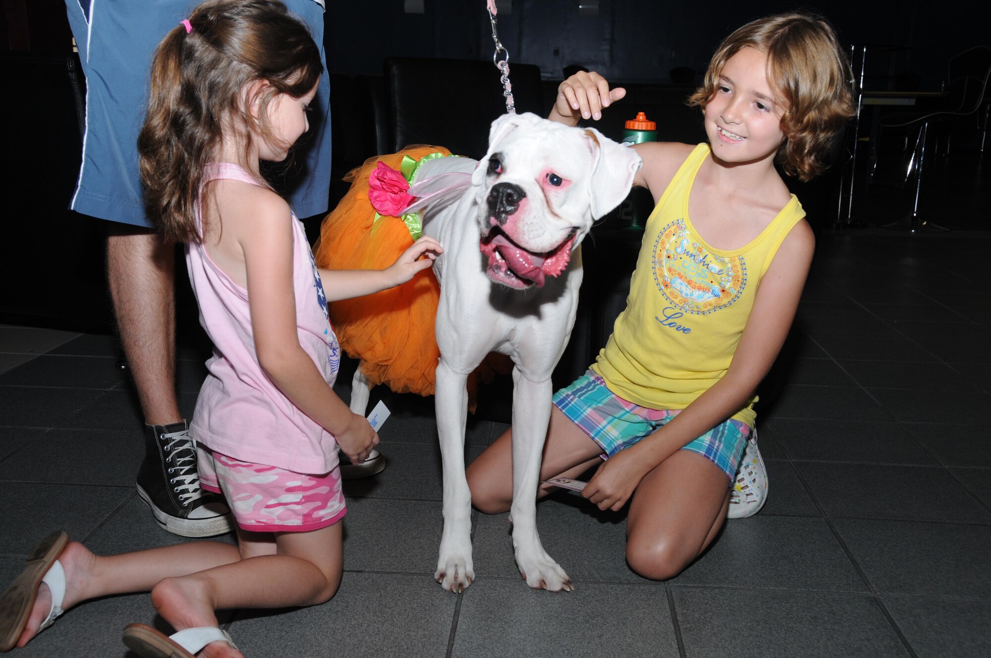 Violet and Ivy McDermott show off their pet boxer, Nacho, at a Strut Your Mutt event at the Vandenberg Community Center, July 22. Violet, 5, and Ivy, 9, are the daughters of Staff Sgt. Ian and Rachel McDermott, 338th Training Squadron.  (U.S. Air Force photo by Kemberly Groue)