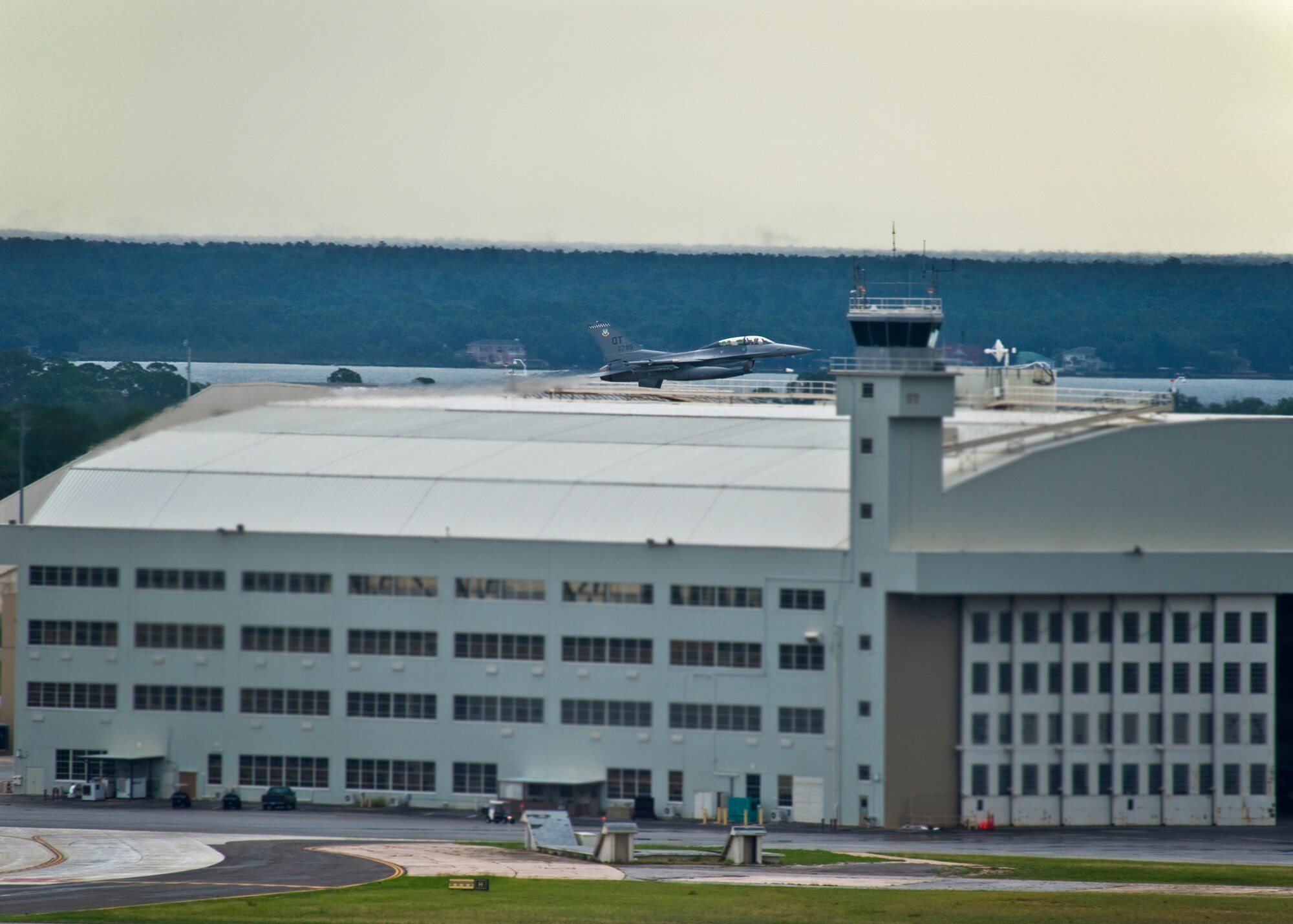 A 53rd Wing F-16 Fighting Falcon soars past Eglin’s famous King Hangar July 22.  The wing is responsible for operational testing and evaluation of new equipment and systems proposed for use by these forces.  (U.S. Air Force photo/Samuel King Jr.)