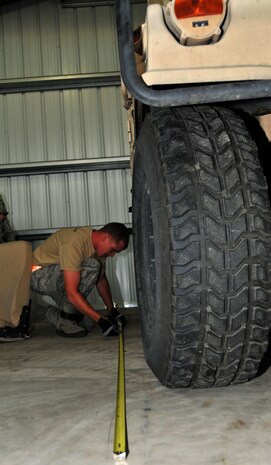 An Airman measures the length of a Humvee, July 27, 2011 at Joint Base Lewis-McChord, Wash., during a joint inspection competition. The event was part of Air Mobility Rodeo 2011, a biennial international competition that focuses on mission readiness, featuring airdrops, aerial refueling and other events that showcase the skills of mobility crews from around the world. (U.S. Air Force photo/Airman 1st Class Jared Trimarchi) 