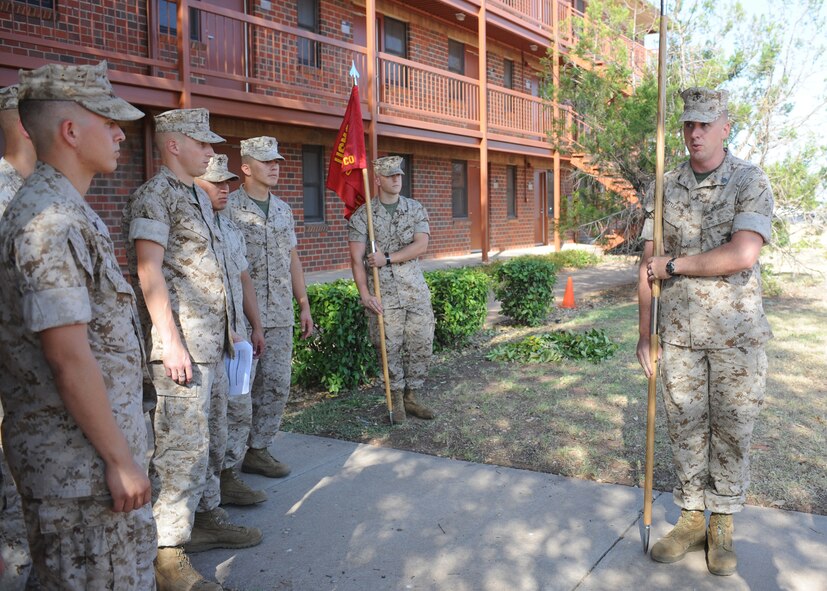 DYESS AIR FORCE BASE, Texas -- Marine Sgt. Brian Littlejohn, Corporals Course instructor, right, demonstrates proper guidon manual maneuvers to Corporals Course students during the Corporals Course July 27, 2011. The Marine’s Enlisted Professional Military Education course is a 16-day course held once a year at Dyess. The course teaches Marine noncommissioned officers (corporals) how to lead in today’s Marine Corps. (U.S. Air Force photo by Airman 1st Class Jenifer H. Calhoun/Released)