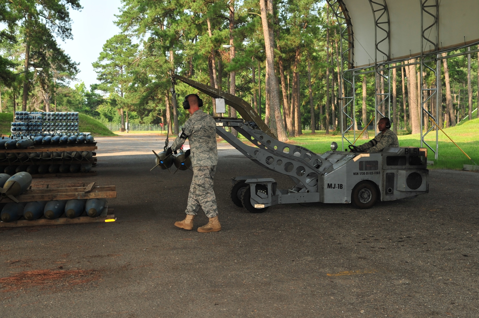 SEYMOUR JOHNSON AIR FORCE BASE, N.C. Staff Sgt. Patric Senchuk directs Senior Airman Kenneth Washington as he uses a jammer to move training bombs onto a platform July 22, 2011. Both Airmen are munitions systems specialist with the 4th Equipment Maintenance Squadron conventional maintenance flight and have participated in the building of every bomb generated here since their arrival. Senchuk is from Alpena, Mich., and Washington is from Tampa, Fla. (U.S. Air Force photo by Senior Airman Marissa Tucker/RELEASED) 