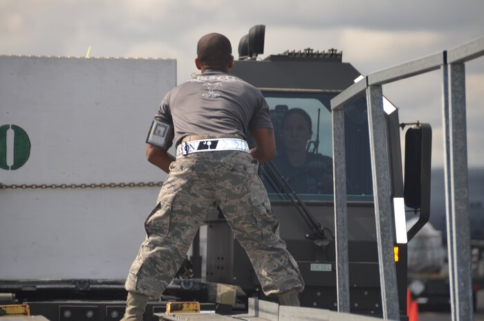 Team Charleston Rodeo member Senior Airman Marvin Richardson directs Staff Sgt. Ashley Kelly the K-loader operator, to align the Halvorsen loader with the high-line dock, a simulated aircraft ramp, during the 25K loader obstacle course July 27 at Joint Base Lewis-McChord, Wash. (U.S. Air Force photo/2nd Lt. Susan Carlson)