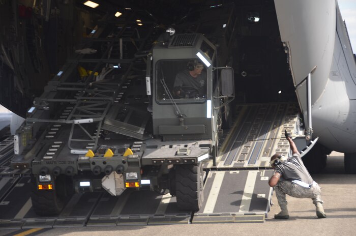 Senior Airman Marvin Richardson directs Staff Sgt. Ashley Kelly, the K-loader operator, to align the Halvorsen loader with the high-line dock, a simulated aircraft ramp, during the 25K loader obstacle course July 27 at Joint Base Lewis-McChord, Wash.