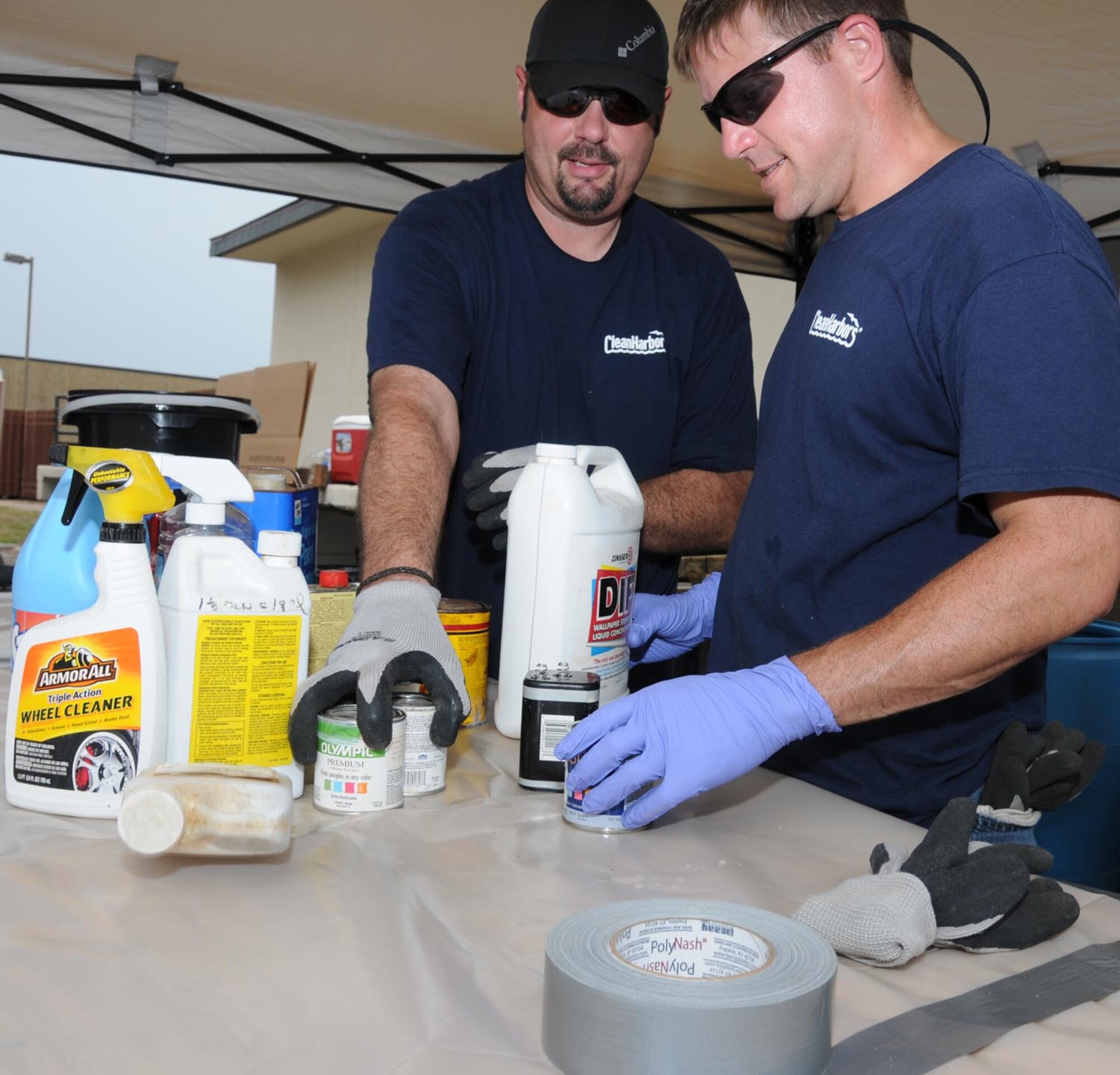 Wayne Smith, left, and Beau Hosch, employees with Clean Harbors Environmental Services in Baton Rouge, La., sort through various household chemicals for proper
disposal July 12. Keesler’s recycling center holds a bi-annual household hazardous
waste turn-in day for base residents and employees.  (U.S. Air Force photo by Kemberly Groue)