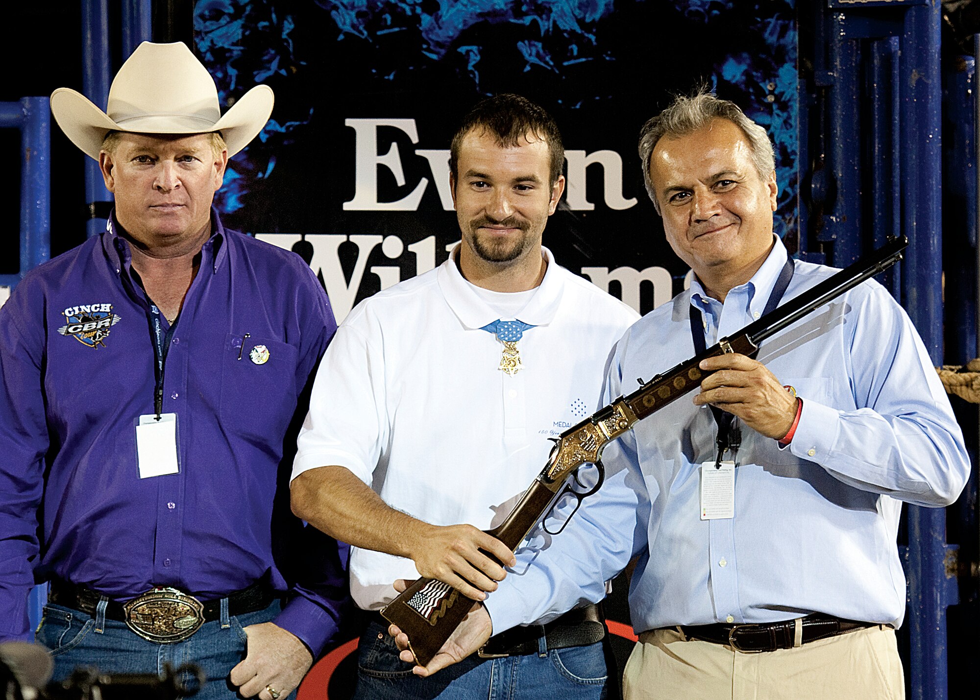 Former Army Staff Sgt. Salvatore Giunta, Medal of Honor recipient, receives a rifle from Anthony Imperato, controller and office manager for Henry Rifle, July 25 during the 115th annual Cheyenne Frontier Days celebration. Giunta is the first living servicemember from the Iraq and Afghanistan wars to receive the Medal of Honor. He received the Medal of Honor for his actions while deployed to Afghanistan in 2007. The rifle presented to Giunta was given to him on Military Appreciation Day. Military members were asked to wear red, white and blue clothing and were allowed into the rodeo for free. (U.S. Air Force photo by Matt Bilden)