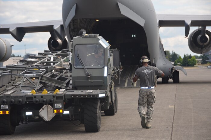 Staff Sgt. Luther Franklin directs Staff Sgt. Nick Sansone, the K-loader operator, during the engine running onload/offload competition July 27 at the Air Mobility Command 2011 Rodeo at Joint Base Lewis-McChord, Wash. (U.S. Air Force photo/2nd Lt. Susan Carlson)