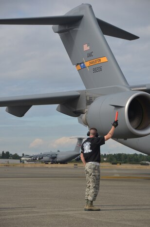 Tech. Sgt. Jessy Martin guides the Team Charleston C-17 Rodeo jet during the Air Mobility Rodeo 2011 July 27 at Joint Base Lewis McChord, Wash. Martin is from the 437th Aircraft Maintenance Squadron. (U.S. Air Force photo/2nd Lt. Susan Carlson)