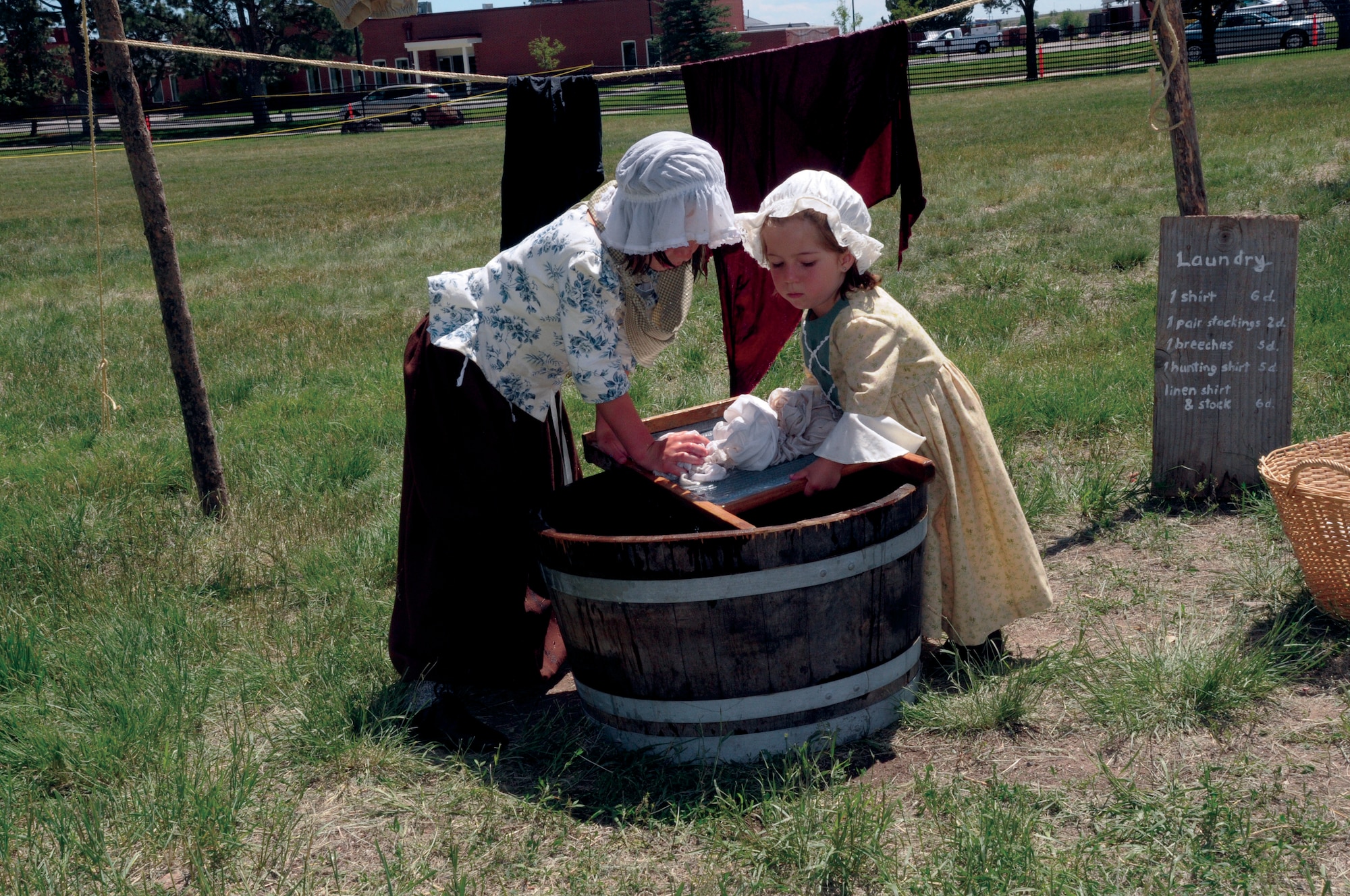Olivia Young, age 9, and her sister Addison Young age 3, from Wheatridge, Colo., demonstrate time era clothes washing during Fort D.A. Russell Days here July 23. (U.S. Air Force photo by Blaze Lipowski)