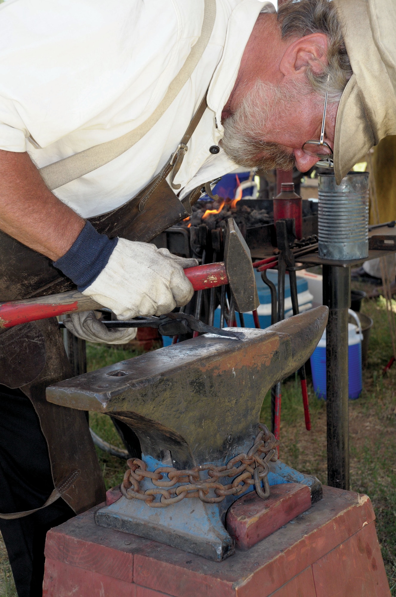 Jan Manning from Fort Collins, Colo., demonstrates the techniques of a blacksmith during Fort D.A. Russell Days here July 23. (U.S. Air Force photo by Blaze Lipowski)