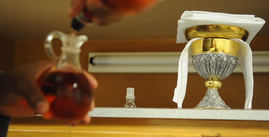 Staff Sgt. Jermain Smith, 2nd Bomb Wing chaplain assistant, pours sacramental wine into a glass container in Chapel 2 on Barksdale Air Force Base, La., July 19. The wine is used for communion during daily mass Monday through Thursday at 11:30 a.m. (U.S. Air Force photo/Airman 1st Class Micaiah Anthony)(RELEASED)