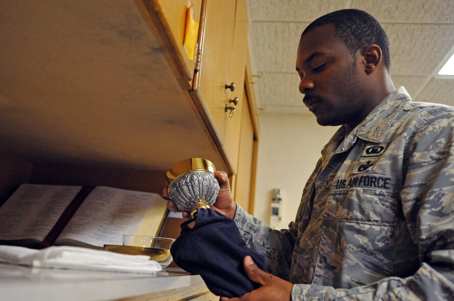 Staff Sgt. Jermain Smith, 2nd Bomb Wing chaplain assistant, removes a chalice from its protective covering at Chapel 2 on Barksdale Air Force Base, La., July 19. The chalice is used for communion during daily mass every Monday through Thursday at 11:30 a.m. (U.S. Air Force photo/Airman 1st Class Micaiah Anthony)(RELEASED)
