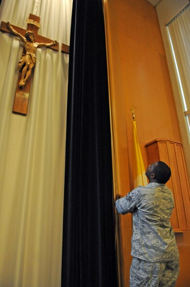 Staff Sgt. Jermain Smith, 2nd Bomb Wing chaplain assistant, pulls curtains back in Chapel 2 on Barksdale Air Force Base, La., July 19. With the exception of Friday, the chapel is set up every day for mass. (U.S. Air Force photo/Airman 1st Class Micaiah Anthony)(RELEASED)
