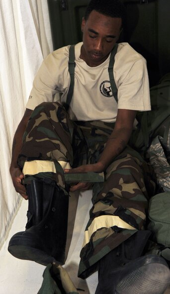 Tech. Sgt. Rodney McInnis, changes into Mission Oriented Protective Posture gear for the chemical warfare portion of the financial management competition July 25, 2011, at Joint Base Lewis-McChord, Wash.  This was the first time Airmen were allowed to compete at Air Mobility Rodeo.  McInnis is 22nd Comptroller Squadron NCO in charge at McConnell Air Force Base, Kan.  (U.S. Air Force/Senior Airman Abigail Klein)