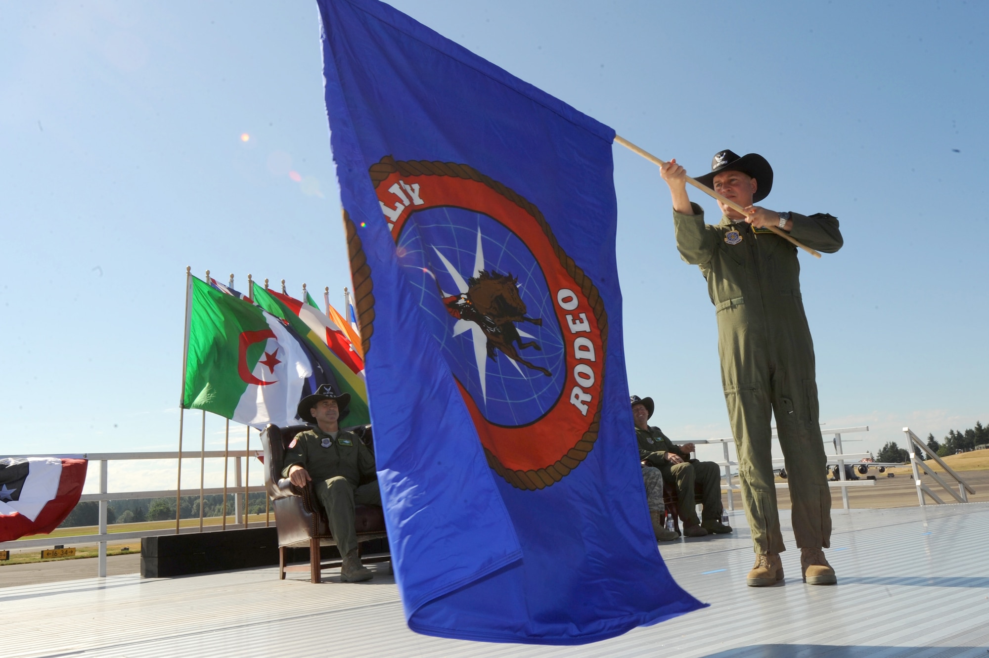 Brig. Gen. Rick Martin, Air Mobility Command director of operations, unfurls the Air Mobility Rodeo 2011 flag during the opening ceremony of the competition at Joint Base Lewis-McChord, Wash., on July 24, 2011. Rodeo is the U.S. Air Force's and Air Mobility Command's premier international combat skills and flying operations competition designed to develop and improve techniques, procedures and interoperability, while optimizing international mobility partnerships and enhancing mobility operations. (U.S. Air Force photo/Staff Sgt. Ashley Moreno)(RELEASED)
