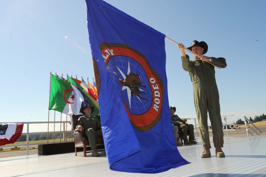 Brig. Gen. Rick Martin, Air Mobility Command director of operations, unfurls the Air Mobility Rodeo 2011 flag during the opening ceremony of the competition at Joint Base Lewis-McChord, Wash., on July 24, 2011. Rodeo is the U.S. Air Force's and Air Mobility Command's premier international combat skills and flying operations competition designed to develop and improve techniques, procedures and interoperability, while optimizing international mobility partnerships and enhancing mobility operations. (U.S. Air Force photo/Staff Sgt. Ashley Moreno)(RELEASED)