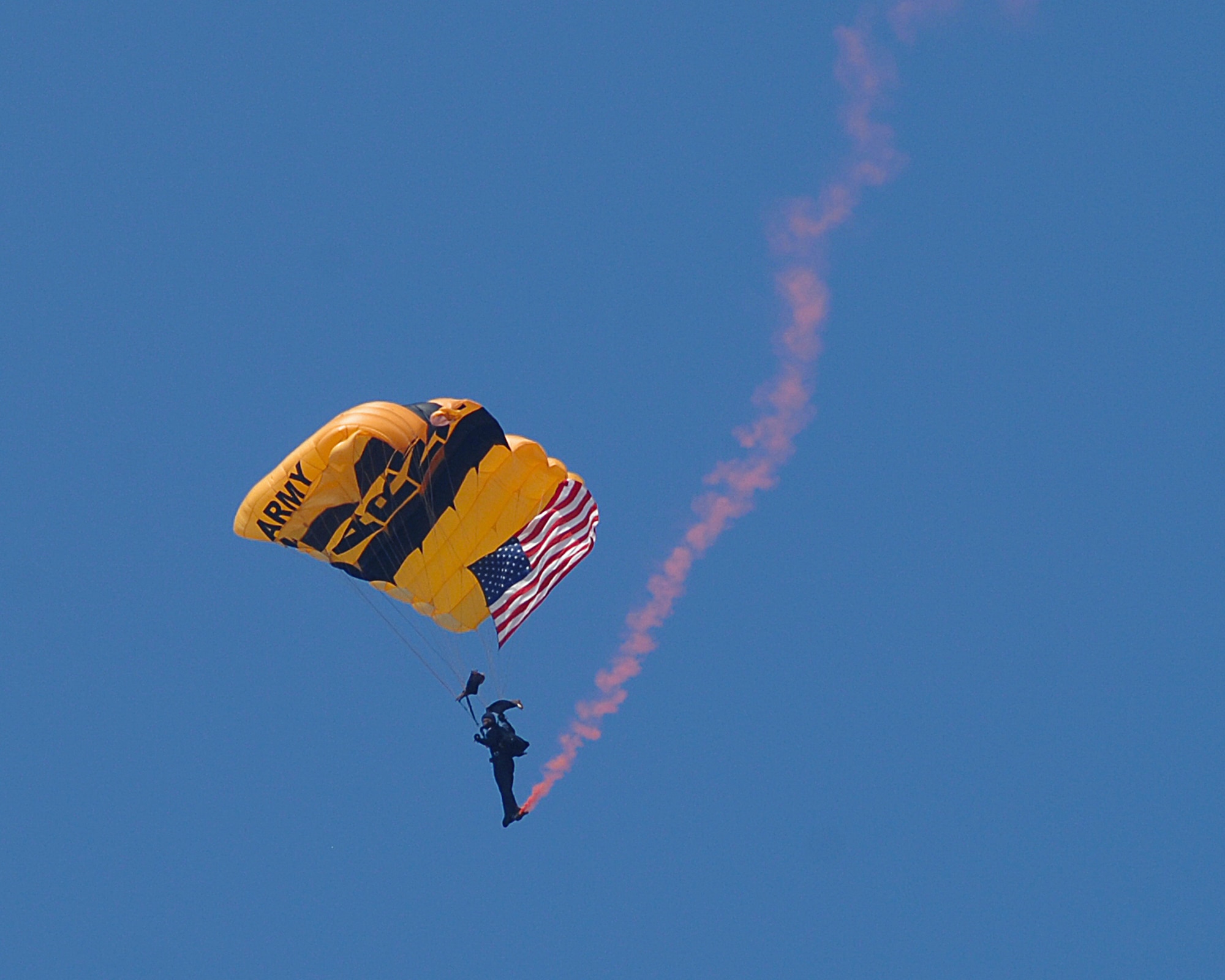 A U.S. Army Golden Knight Parachute Team member makes a smoke trailed entrance into the Dayton Air Show. (USAF photo by Ben Strasser)