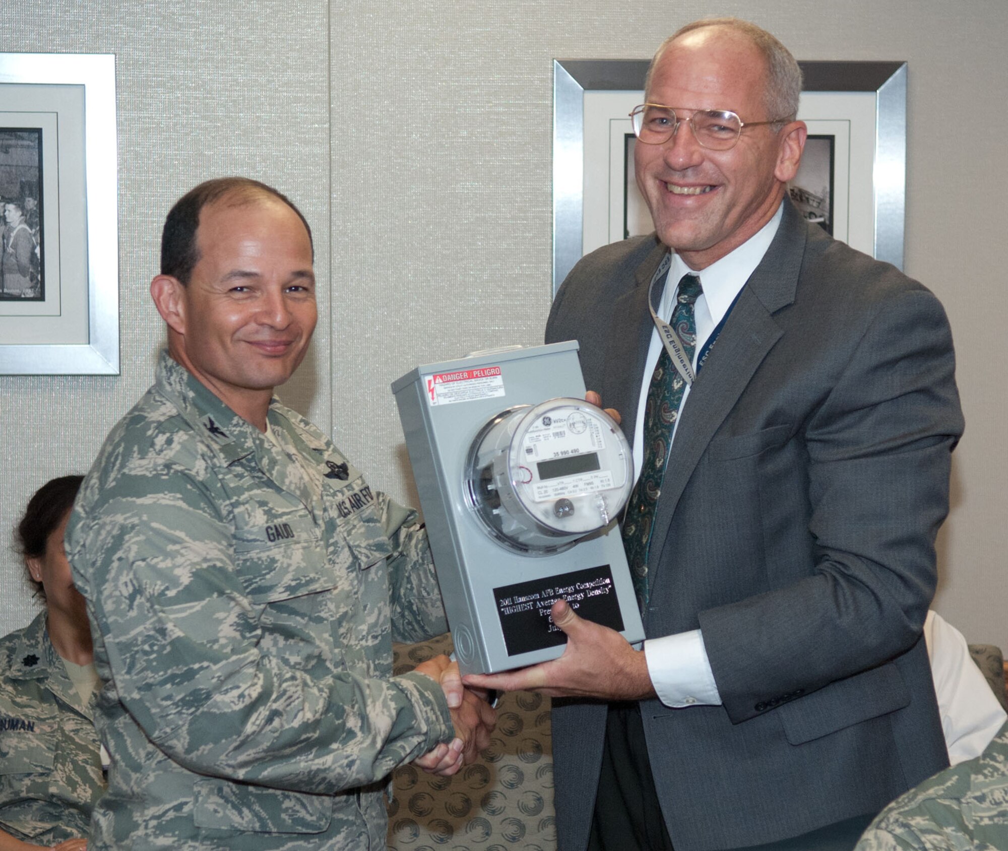 HANSCOM AIR FORCE BASE, Mass. – Col. Juan Gaud (left), 66th Air Base Group deputy commander, accepts an award for Highest Average Energy Intensity from Tom Schluckebier, base civil engineer, during the Electronic Systems Center staff meeting July 21. Although the air base group recorded the highest energy usage across the base, they were also awarded as the “Biggest Loser” for lowering their energy consumption during the Hanscom Energy Reduction Competition held from Jan. 1 to June 30, 2011. (U.S. Air Force photo by Rick Berry)