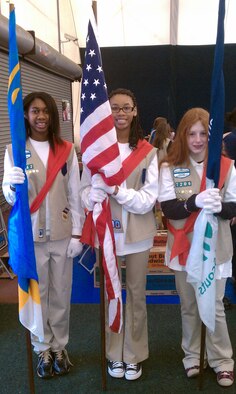 HANSCOM AIR FORCE BASE, Mass. – Ytrenda Gulley (middle), Hanscom Youth of the Year, prepares to present the United States flag during the Girl Scout Cookie Drop in the Tennis Bubble in February. In addition to Girl Scouts, Ms. Gulley is involved in a wide variety of community activities and service. (Courtesy photo)
