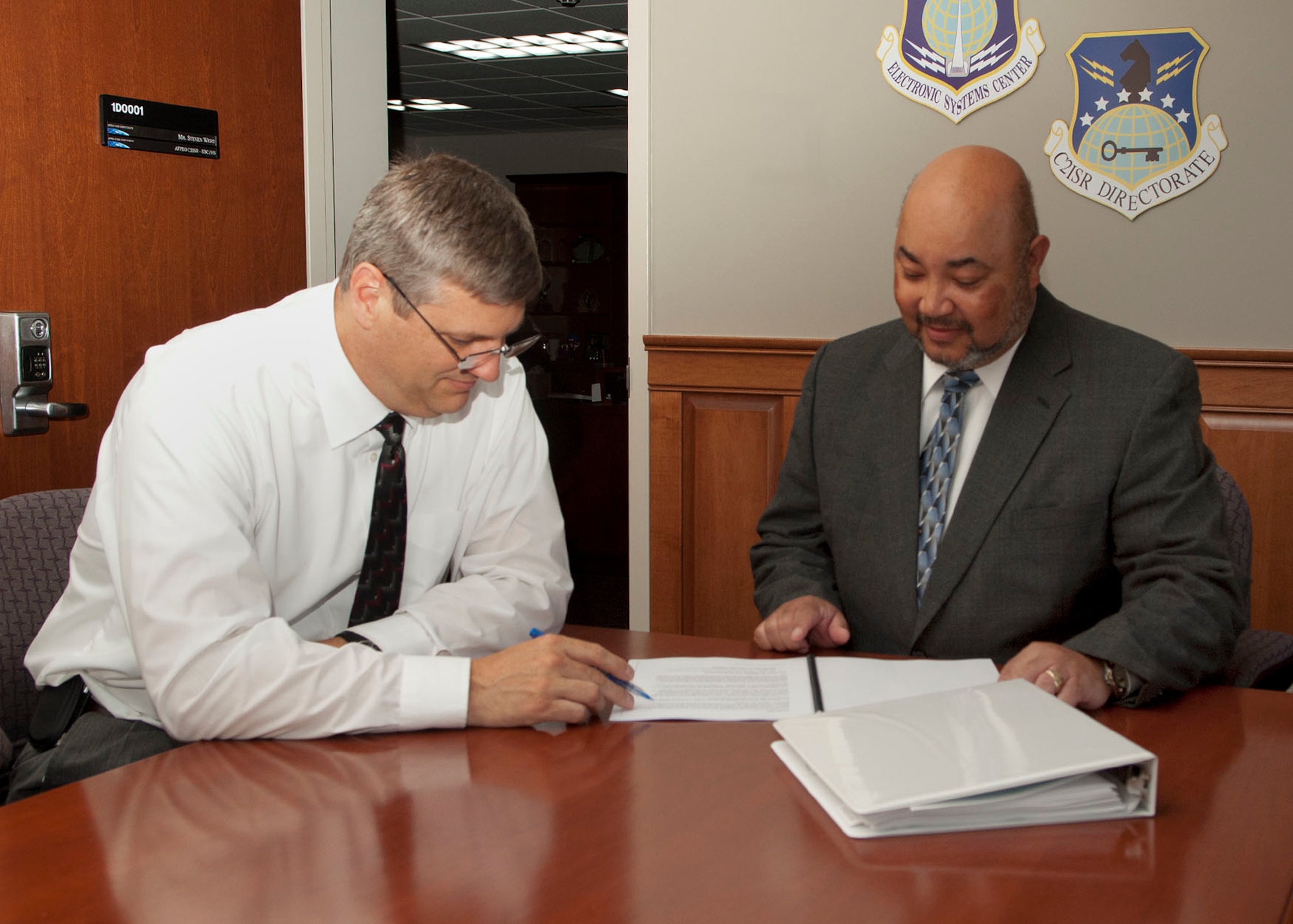 HANSCOM AIR FORCE BASE, Mass.- Albert Griggs Jr. (right), deputy director for the Command and Control, Intelligence, Surveillance and Reconnaissance (C2ISR) Directorate, discusses paperwork with Clif Nees, C2ISR Program Execution Group chief on July 22. Tom Powis, who previously held the deputy position, moved to a new job in the Cyber/Netcentric Directorate.  (U.S. Air Force photo)