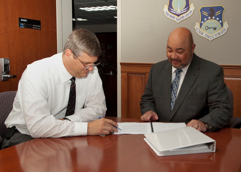 HANSCOM AIR FORCE BASE, Mass.- Albert Griggs Jr. (right), deputy director for the Command and Control, Intelligence, Surveillance and Reconnaissance (C2ISR) Directorate, discusses paperwork with Clif Nees, C2ISR Program Execution Group chief on July 22. Tom Powis, who previously held the deputy position, moved to a new job in the Cyber/Netcentric Directorate.  (U.S. Air Force photo)