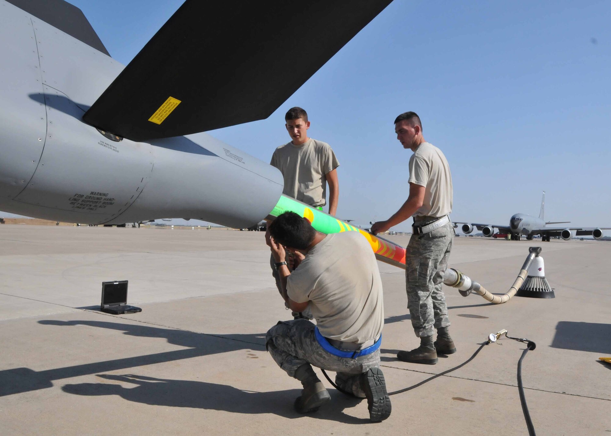 Airman Barrett I. Goulding (left), Airman 1st Class Timothy D. Donahoo (middle), and Staff Sgt. Lance I. Urey perform an hourly post-flight inspection on the air refueling boom of a KC-135 Stratotanker while deployed with the 313th Air Expeditionary Wing in Western Europe on July 28, 2011.