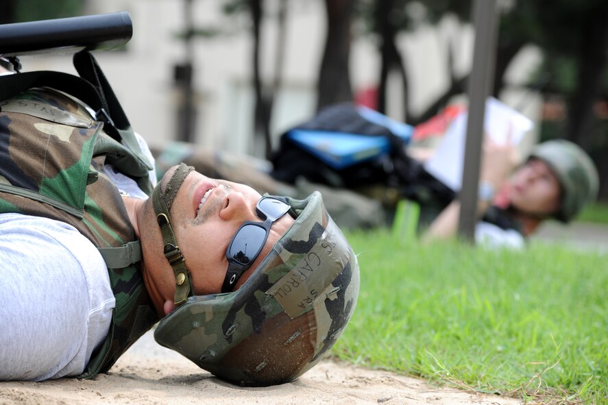 KUNSAN AIR BASE, Republic of Korea -- U.S. Force Senior Airman Travis Carroll, a member of 8th Communications Squadron, lies on the ground simulating being hurt after receiving an inject for a scenario during Exercise Beverly Midnight 11-3 here July 26. Kunsan AB is participating in a base wide operational readiness exercise to evaluate its readiness and its ability to conduct wartime mission.  (U.S. Air Force photo/Staff Sgt. Rasheen Douglas)(Released)