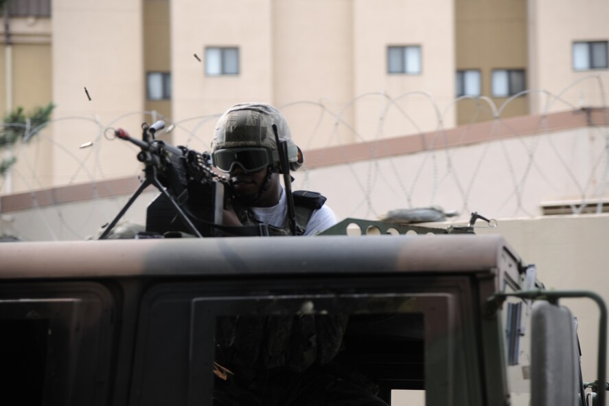 KUNSAN AIR BASE, Republic of Korea -- A member of the 8th Security Forces Squadron, simulates firing upon enemy forces during Exercise Beverly Midnight 11-3 here July 26. Kunsan AB is participating in a base wide operational readiness exercise to evaluate its readiness and its ability to conduct wartime mission.  (U.S. Air Force photo/Staff Sgt. Rasheen Douglas)(Released)