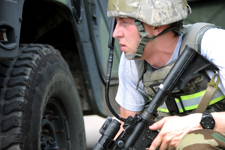 KUNSAN AIR BASE, Republic of Korea -- U.S. Air Force Airman 1st Class James Cline, a member of the 8th Security Forces Squadron, peers intensely around a humvee for invading enemy forces during Exercise Beverly Midnight 11-3 here July 26. Kunsan AB is participating in a base wide operational readiness exercise to evaluate its readiness and its ability to conduct wartime mission.  (U.S. Air Force photo/Staff Sgt. Rasheen Douglas)(Released)